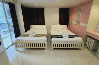 two twin beds in a room with a window at Zenith Life Hotel in Ban Bang Khen (1)