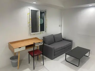 a living room with a couch and a desk at Am Am Place C แอม แอม เพลส C Near Rajmangkala Stadiume in Sathani Khlong Tan
