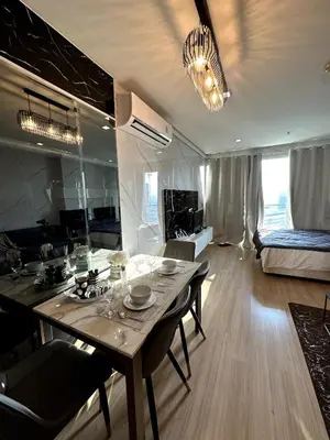 a kitchen and living room with a table and a couch at Sky Residence in Ekkamai in Bangkok