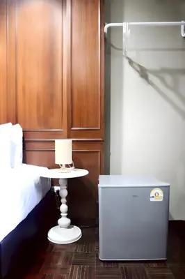 a bedroom with a bed and a nightstand next to a table at Stay On Sukhumvit Soi 11 - สเตย์ ออน สุขุมวิท 11 in Bangkok