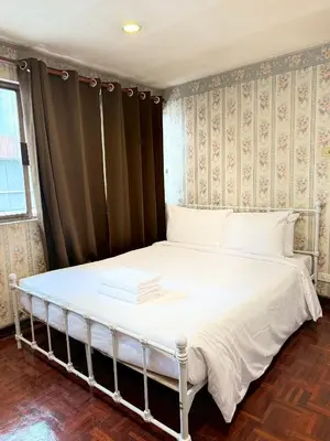 a bedroom with a bed with white sheets at Stay On Sukhumvit Soi 11 - สเตย์ ออน สุขุมวิท 11 in Bangkok
