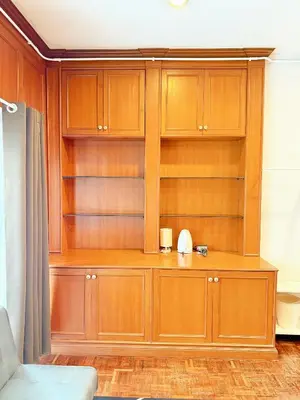 a large wooden cabinet in a room at Stay On Sukhumvit Soi 11 - สเตย์ ออน สุขุมวิท 11 in Bangkok