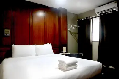 a bedroom with a white bed with towels on it at Stay On Sukhumvit Soi 11 - สเตย์ ออน สุขุมวิท 11 in Bangkok