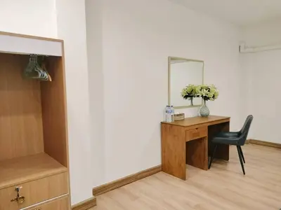a room with a desk and a mirror and a chair at Vintana Siam Bangkok Hotel in Bangkok