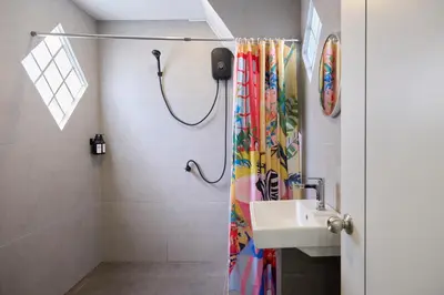 a bathroom with a shower curtain and a sink at Cozy&Modern 6-BR Home, 14pax - Central, 5mins BTS in Bangkok