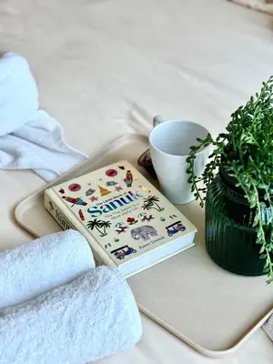 a book sitting on a tray next to a plant at Luxury Prime Thong Lor - Fast WiFi, Gym&Pool in Bangkok