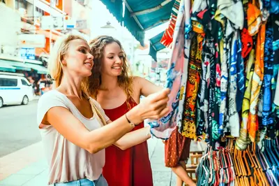 two women standing in front of a clothing store at XX GO INN Khaosan - โกอินน์ ถนนข้าวสาร in Bangkok