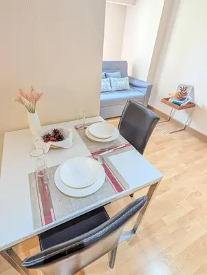 a table and chairs with plates on it in a living room at Executive Suite 1BR and Sofa Bed 150m to Nana BTS in Bangkok