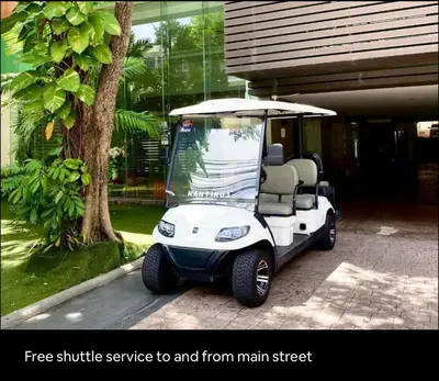 a white golf cart parked in front of a house at Executive Suite 1BR and Sofa Bed 150m to Nana BTS in Bangkok
