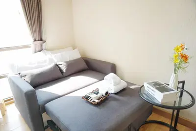 a living room with a couch and a glass table at Executive Suite 1BR and Sofa Bed 150m to Nana BTS in Bangkok