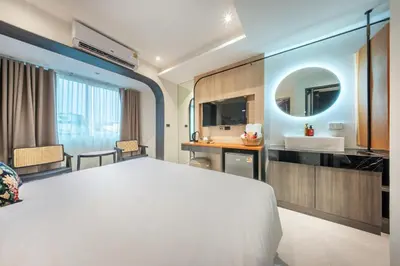 a bedroom with a large white bed and a sink at U TOR Yaowarat - Bangkok Chinatown in Bangkok