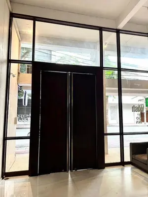 a large black door in a room with windows at XX Wish Inn Silom BKK - วิช อินน์ สีลม in Bang Rak