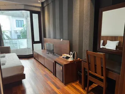 a bedroom with a bed and a desk with a television at XX Wish Inn Silom BKK - วิช อินน์ สีลม in Bang Rak