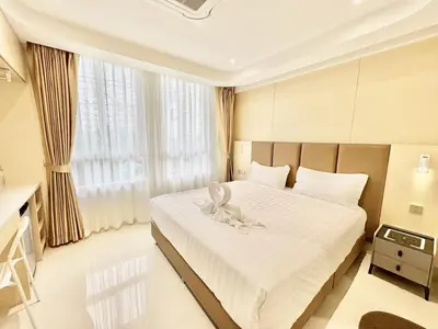 a bedroom with a large bed with a white bedspread at ABCQQ Hotel Bangkok in Bangkok