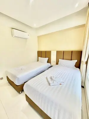 two beds with white sheets in a room at ABCQQ Hotel Bangkok in Bangkok