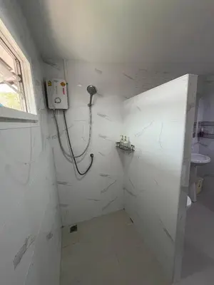 a white bathroom with a shower and a sink at Baan Saen Saran guest house in Bangkok