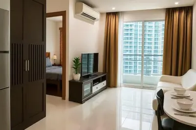 a living room with a couch and a television in a room at The Condo C - Luxury Condo with Onsen in Bangkok