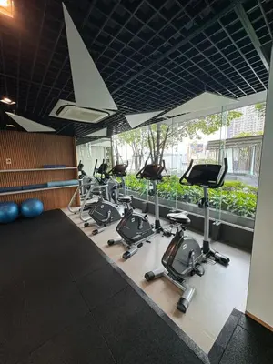 a gym with a row of treadmills and exercise bikes at The Elite Club - ThongLor Bangkok in Bangkok