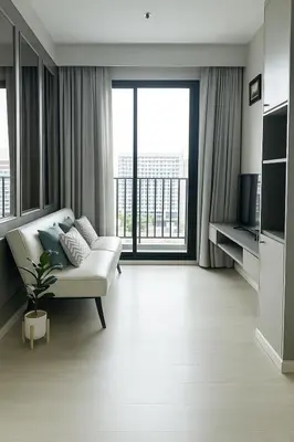 a living room with a white couch and a large window at The Elite Club - ThongLor Bangkok in Bangkok