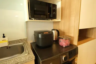 a small kitchen with a microwave and a sink at The Silent Sanctum in Bangkok