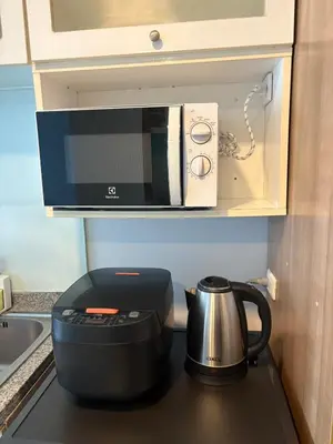 a microwave sitting on top of a stove with a tea kettle at The Silent Sanctum in Bangkok