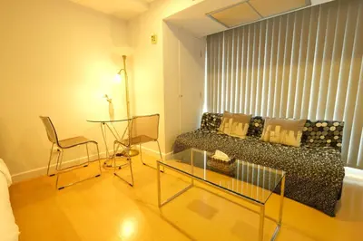 a living room with a couch and a glass table at The Silent Sanctum in Bangkok
