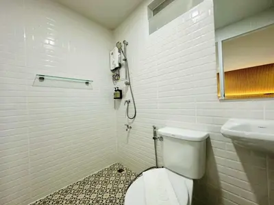 a bathroom with a toilet and a sink at The Cozy 77 in Bangkok