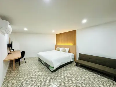 a hotel room with a bed and a desk at The Cozy 77 in Bangkok