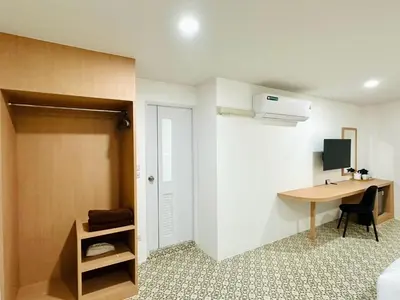 a room with a desk and a bedroom with a bed and a computer at The Cozy 77 in Bangkok