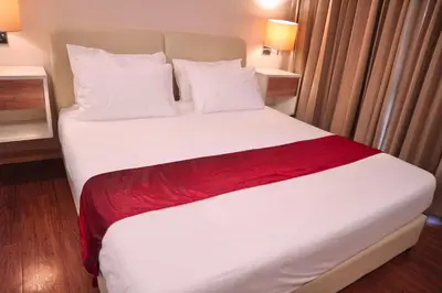 a bedroom with a large white bed with red blanket at ICON NARINDRA SUITES HOTEL Sukhumvit Bangkok Thailand 50sqm to 90sqm Rooms & FREE Minibar in Bangkok