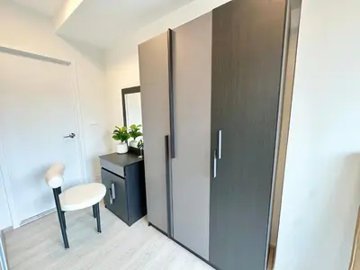a room with a door with a chair and a table at Cosy apartment in Bangkok