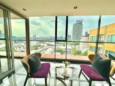 a room with two chairs and a table and a large window at Cosy apartment in Bangkok