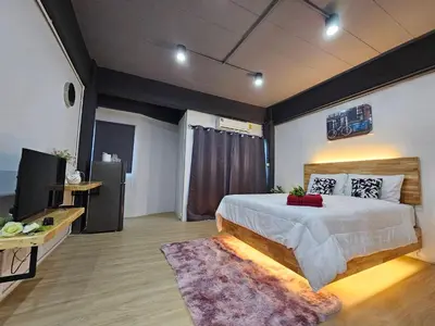 a bedroom with a large bed and a television at Irich Bang Hua Suae 6kms from BTS Pu-Chao in Ban Bang Chak