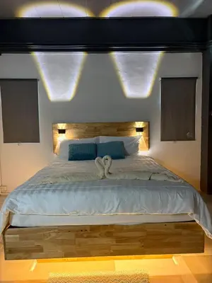 a bedroom with a large bed with lights above it at Irich Bang Hua Suae 6kms from BTS Pu-Chao in Ban Bang Chak