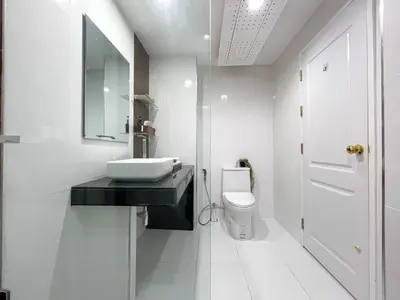 a white bathroom with a sink and a toilet at Modern Cityscape1BR - Ultra Fast WiFi - BTS On nut in Bangkok