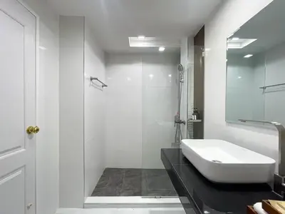 a white bathroom with a sink and a shower at Modern Cityscape1BR - Ultra Fast WiFi - BTS On nut in Bangkok