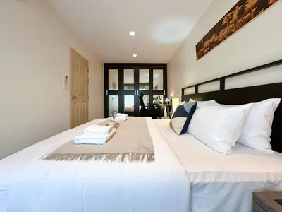 a bedroom with a large white bed with white pillows at Vibrant Modern 57 SQM - Ultra Fast WiFi - BTS Thonglor in Bangkok
