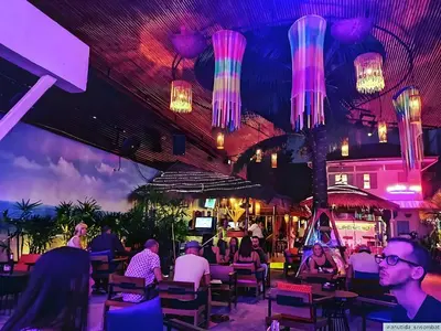 people sitting at tables in a restaurant with lights at XX GO INN Khaosan - โกอินน์ ถนนข้าวสาร in Bangkok