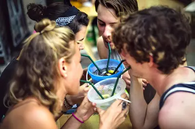 a group of people eating a bowl of food at XX GO INN Khaosan - โกอินน์ ถนนข้าวสาร in Bangkok