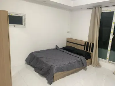 a bedroom with a bed and two windows at Am Am Place D Near Rajamangala in Sathani Khlong Tan