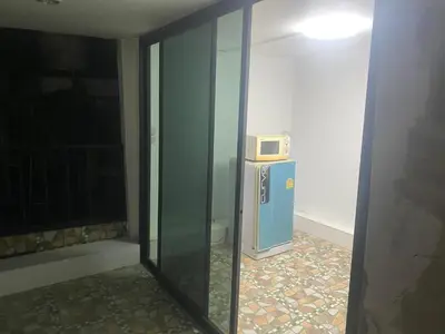 a room with a microwave on top of a refrigerator at Am Am Place D Near Rajamangala in Sathani Khlong Tan