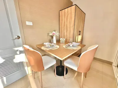 a dining room with a wooden table and chairs at Studio with view near Ekkamai in Bangkok