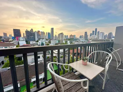 a balcony with a table and chairs and a city skyline at Studio with view near Ekkamai in Bangkok