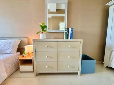 a bedroom with a dresser and a mirror at Cosy 2 bedrooms near Ekkamai in Bangkok