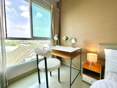 a bedroom with a desk and a window with a view at Cosy 2 bedrooms near Ekkamai in Bangkok