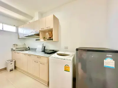 a small kitchen with a refrigerator and a dishwasher at Cosy 2 bedrooms near Ekkamai in Bangkok