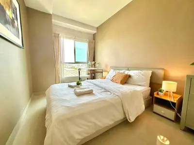 a bedroom with a large white bed and a window at Cosy 2 bedrooms near Ekkamai in Bangkok