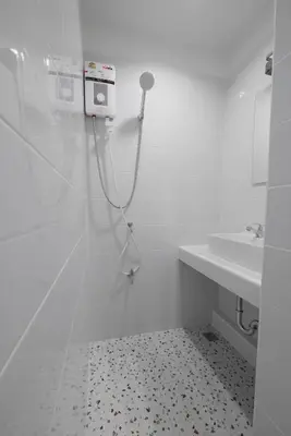 a white bathroom with a shower and a sink at Lee Home Bangkok in Bangkok
