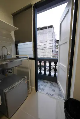 a kitchen with a door open to a balcony at Lee Home Bangkok in Bangkok