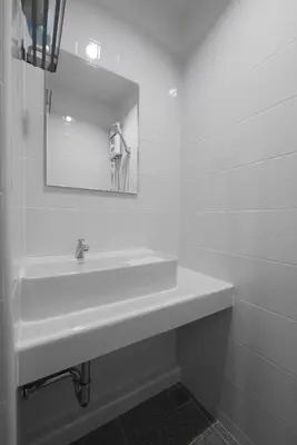 a white bathroom with a sink and a mirror at Lee Home Bangkok in Bangkok